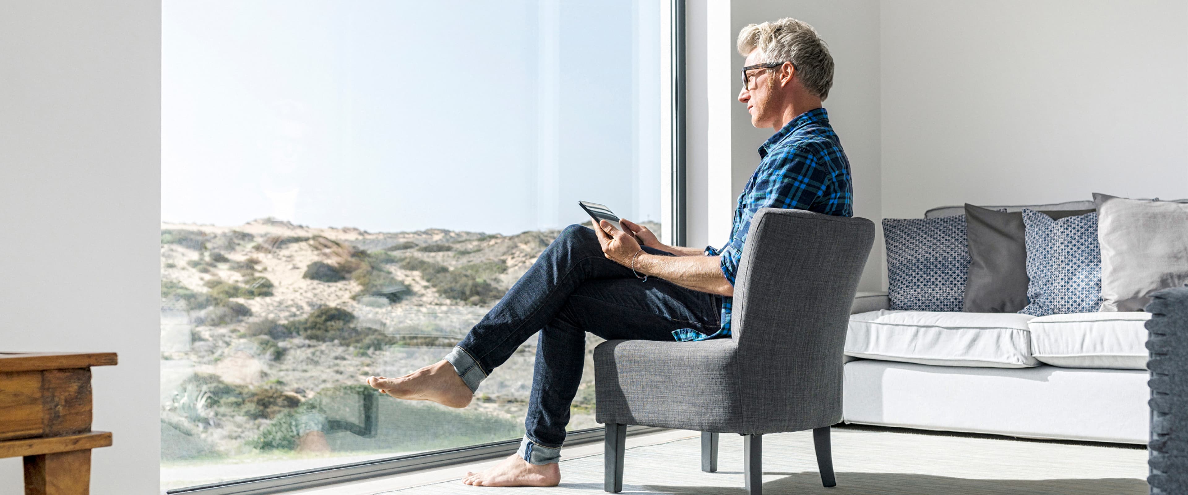 a Person is sitting in a chair in front of a window looking at a table